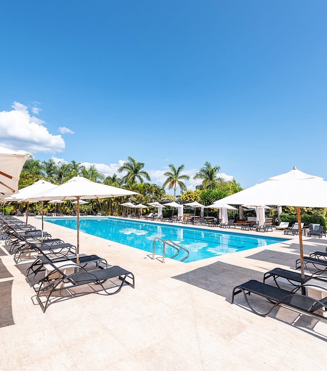 Piscina com espreguiçadeiras e guarda-sóis no clube